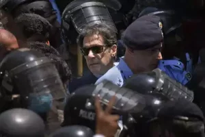 Pakistan's former Prime Minister Imran Khan, center, is escorted by police officers as he arrives to appear in a court, in Islamabad.